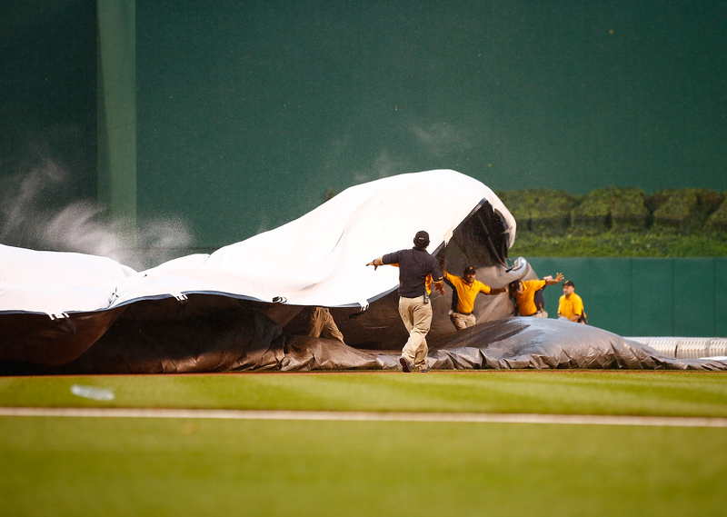 Illustration for article titled It Takes A Village To Secure An Infield Rain Tarp